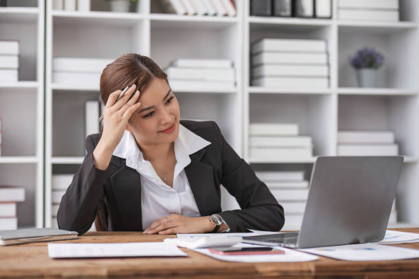 istock Tired young woman is sitting at the table at work in the office 1694859628