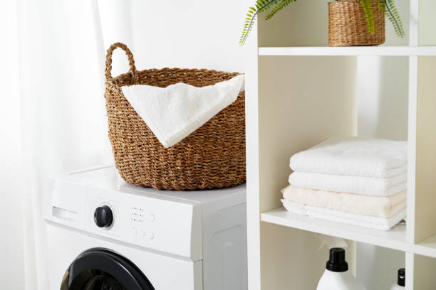 istock Laundry room with washing machine and basket with laundry 1694885786
