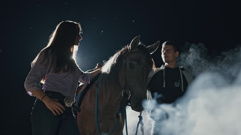 SLO MO Young Couple Standing with Horse on Ranch in Dark at Night Surrounded with Fog