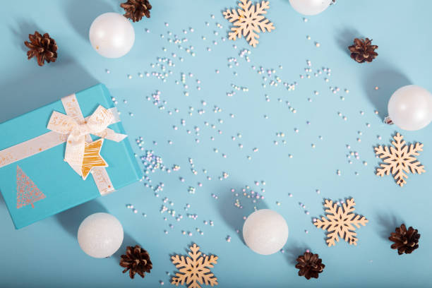 istock Christmas decoration. Gift boxes and Christmas decorations on pastel blue background, flat lay. Top view. Copy space 1694916053