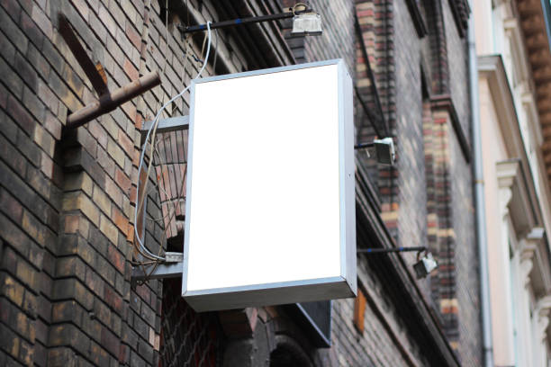 istock Mounted square sign on a wall with urban brick environment for advertising mockup. Template for logo, branding and corporate identity of shop, cafe, restaurant. 1694921143