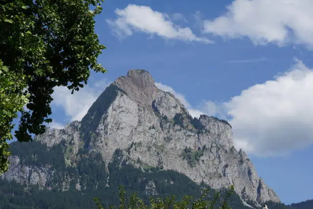 Mountain called Grosser Mythen located in Swiss Alps, in canton Schwyz, Switzerland. There are trees framing the capture from the left side.