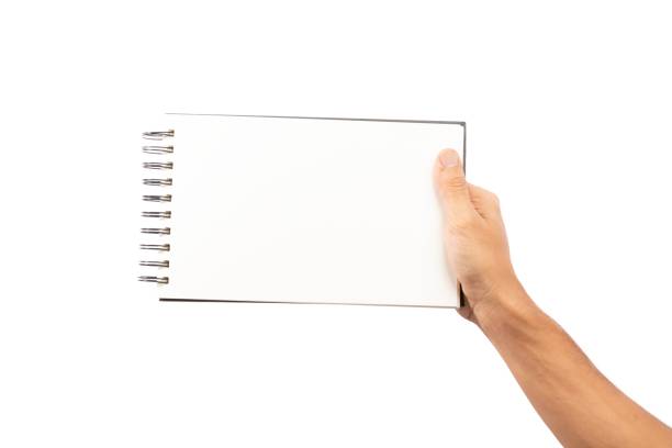 istock Black male hand holding a blank sketchbook or notebook isolated no background 1694926591