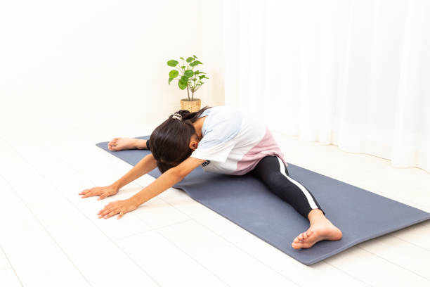 A girl stretching in her room. A girl stretching in her room. legs apart stock pictures, royalty-free photos & images