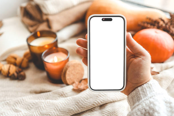 istock Phone with an isolated screen in hands, autumn mood 1694953365