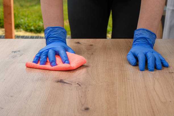 istock A woman wipes dust from a wooden table with a microfiber cloth 1694972238