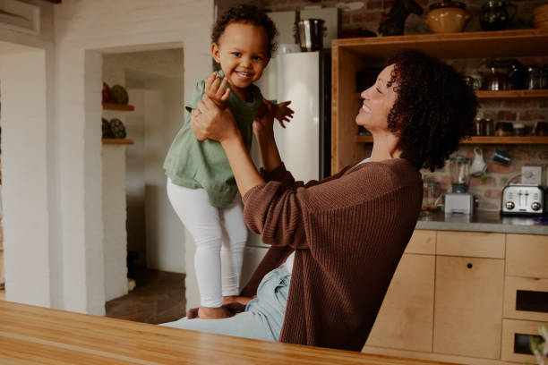 istock Biracial mother playing with daughter in kitchen at home 1695028396