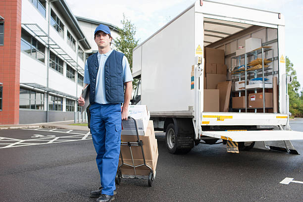 deliveryman puling ボックスを台車 - 台車 ストックフォトと画像