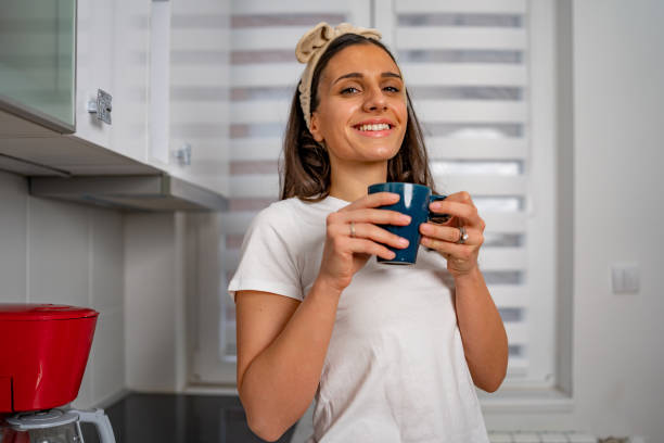 istock Young woman fuels up with coffee in her modern kitchen 1695032526