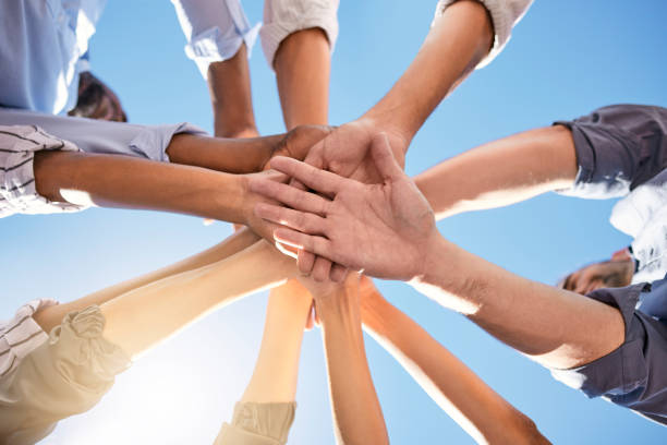 istock Low angle, hands and circle in success, solidarity or support team building, teamwork collaboration or diversity celebration. Men, women and friends in community huddle for business motivation goals 1695036393