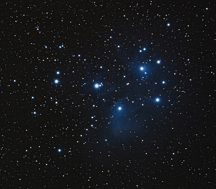 An ethereal image of the Pleiades, also known as the Seven Sisters, a prominent star cluster visible from Earth. This tight grouping of stars, residing in the constellation Taurus, has been marveled at since ancient times and holds significance in various mythologies and cultures.