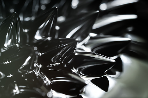 Magnetic liquid spikes. Ferrofluid reacting to a magnetic field. Minimalistic futuristic macro photo. High contrast detailed dark themed photo. Clean composition. Realistic.