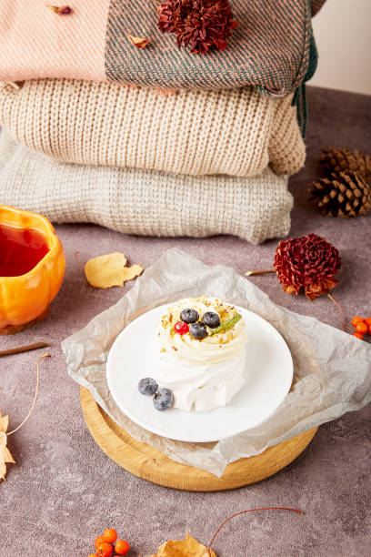 istock Autumn Pavlova Delight with tea cup. Sweater weather concept. Cozy home 1695062425