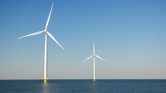 Wind Farm. Windmill farm in the ocean. Offshore wind turbines in the sea. Wind turbine from an aerial view