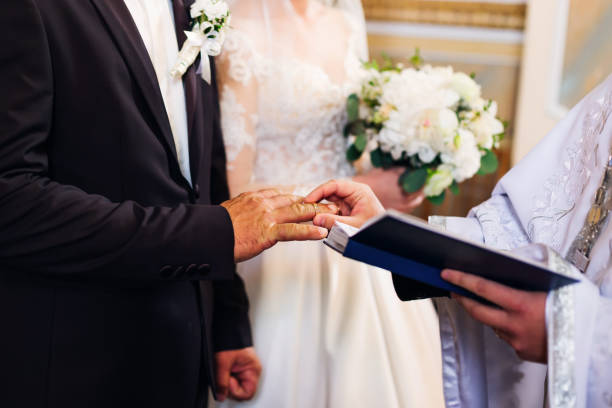 istock wedding ceremony, newlyweds standing before the priest who conducts wedding 1695118415