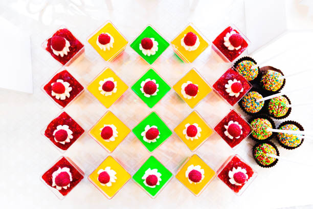 top view of a multicolored jelly with cream and raspberry and candy in a brown wrap with colored peas