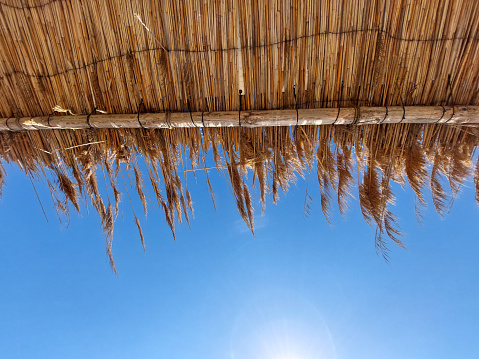 Straw hay roof against blue sky background