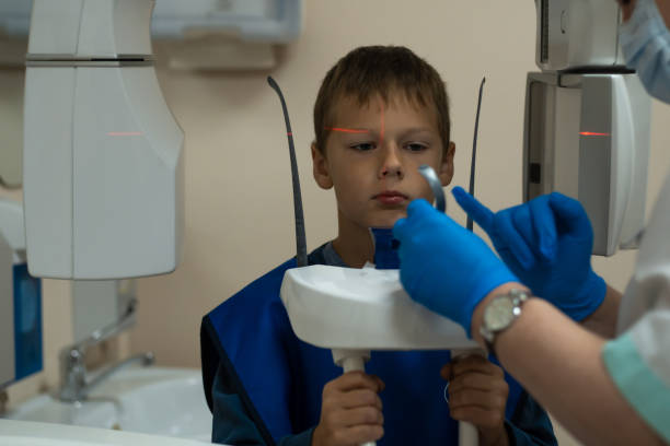 istock Jaw computed tomography, check up teeth in dental clinic. Boy in vest on x-ray diagnostics. Circular snapshot of jaw. 1695134228