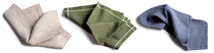 Linen textile napkin set isolated on white background. Beige, green, blue soft cotton napkins.