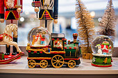 New Year's toy steam locomotive with a sleeping woman on the store counter. New Year's window decoration
