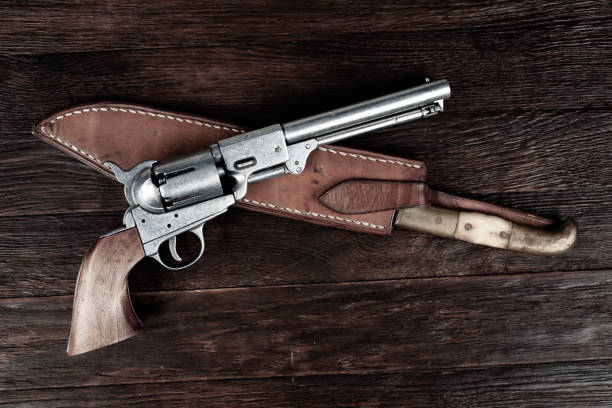 istock Old west weapon. Colt Revolver and knife with holster on deck. 1695155497