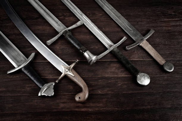 istock Swords and sabre on wooden backgrond. 1695159536