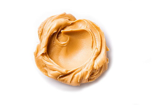 Peanut Butter isolated on white background. Swirl of peanut spread close up.