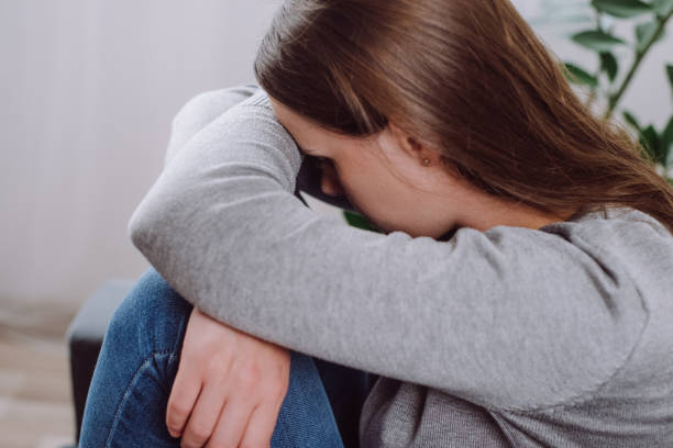 istock Depressed sad young woman sitting on sofa in living room, expression to face difficulty, failure and exhausted. Worried upset Caucasian female 25s suffering depression feeling lonely, alone at home 1695166284