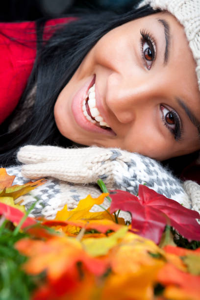 istock Smiling woman laying on fallen Autumm leaves 1695205161