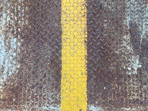 The steel plates placed in the parking lot have yellow lines.