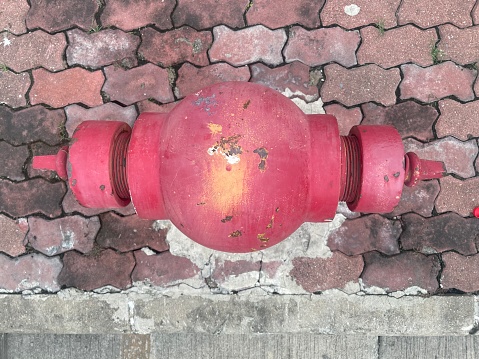 The red fire hydrant has peeling paint.