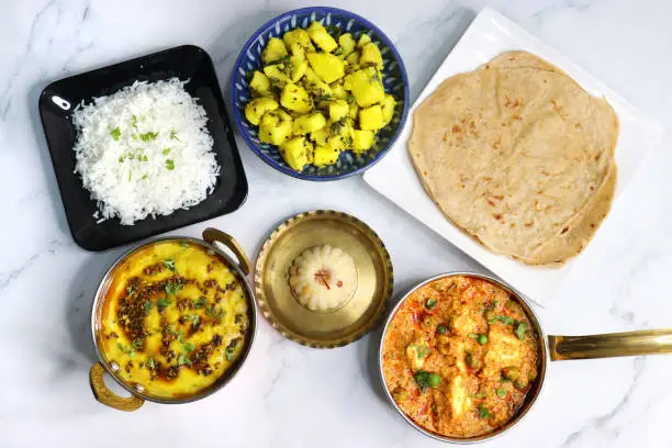 Indian vegetarian Thali or platter includes Aloo ki sabji, dal rice, Roti bhaji, Matar Paneer, Sheera or suji ka halwa, chapati. Indian food is served in a Silverplate or thali. Copy Space. Veg Thali