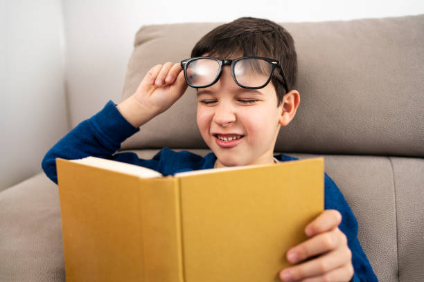 istock Child suffering eyes strain trying to read 1695222063
