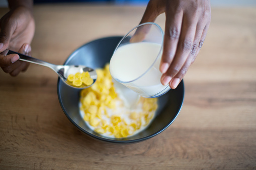Unrecognizable Person Pouring a Milk into a Bowl of Cereal.