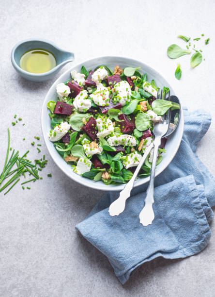 istock Light dietetic salad with goat cheese, beetroot pieces, walnuts, olive oil and herbs. Mediterranean salads, typical dishes of Spain, France,  Greece, Turkey and Italy, front view 1695227225