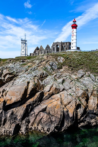 A majestic lighthouse atop a rocky cliff, overlooking the vast Brittany sea