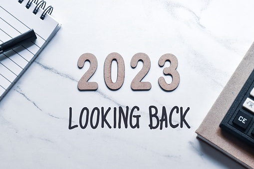 2023 Looking Back inscription with wooden 3d numbers on desk. White background, top view. 2023 review recap highlights of the year concept.