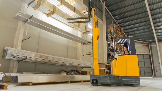 Worker moving goods with an electric forklift truck