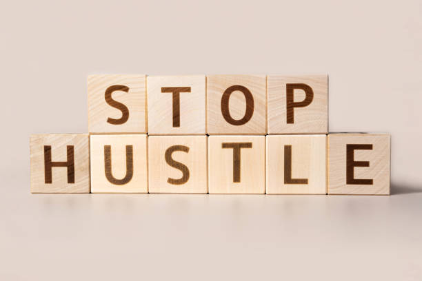 istock The word STOP HUSTLE on cubes on a beige studio background. Copy Space. Written. Text words matter. Conceptual Image. Concept of maintaining mental health while working overtime. Don't work long hours 1695303549