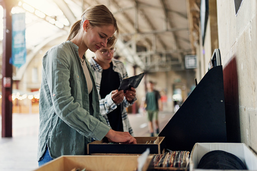 Teenagers browsing vinyl records on street stands if a charity shop.
Shot with Canon R5