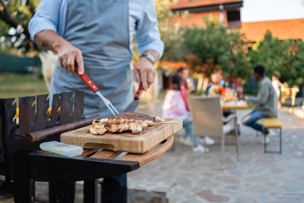 istock Unrecognizable senior man making barbecue for his large multiracial family 1695328143