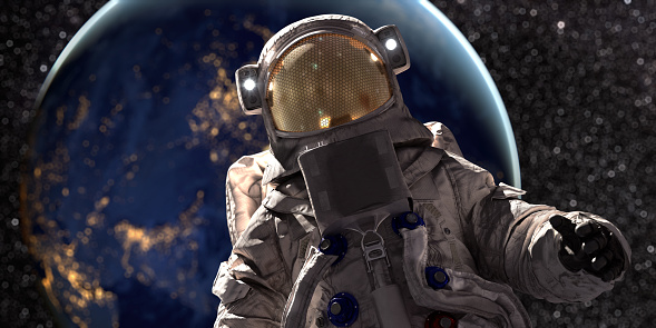 A close up portrait of an astronaut in full space suit holding out one hand whilst on a space walk with planet Earth in the background. Shallow depth of field with selective focus on the helmet.