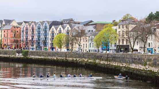 Cork, Ireland - April 16, 2023: Cityscape with rowing boat in the Lee river in the center of Cork in Munster province in Ireland Europe