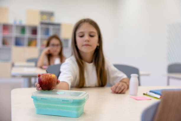 istock Cute long-haired girl having lunch at school 1695371687