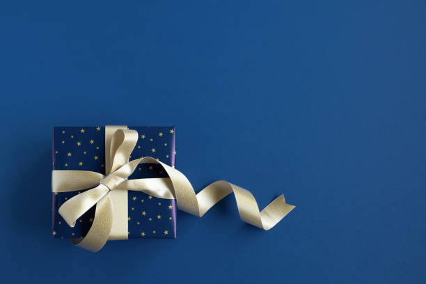 istock Banner with blue gift box with gold ribbon on a blue background. 1695373628