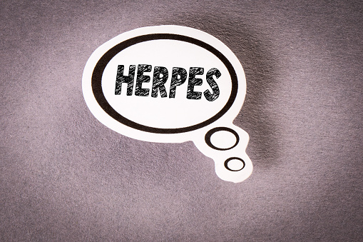 HERPES. Speech bubble with text on gray background.