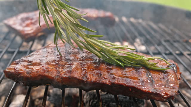 SLO MO Brushing ribs on the grill using a rosemary sprig
