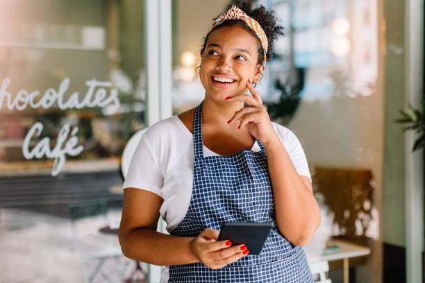 istock Female entrepreneur standing in her cafe, smiling pensively 1695443051