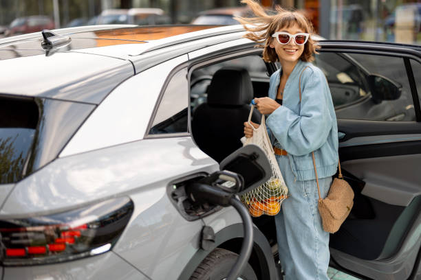 Woman charging electric car while shopping