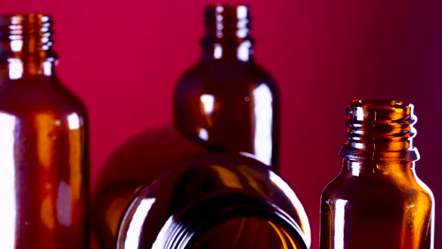 empty glass medicine bottle on red background